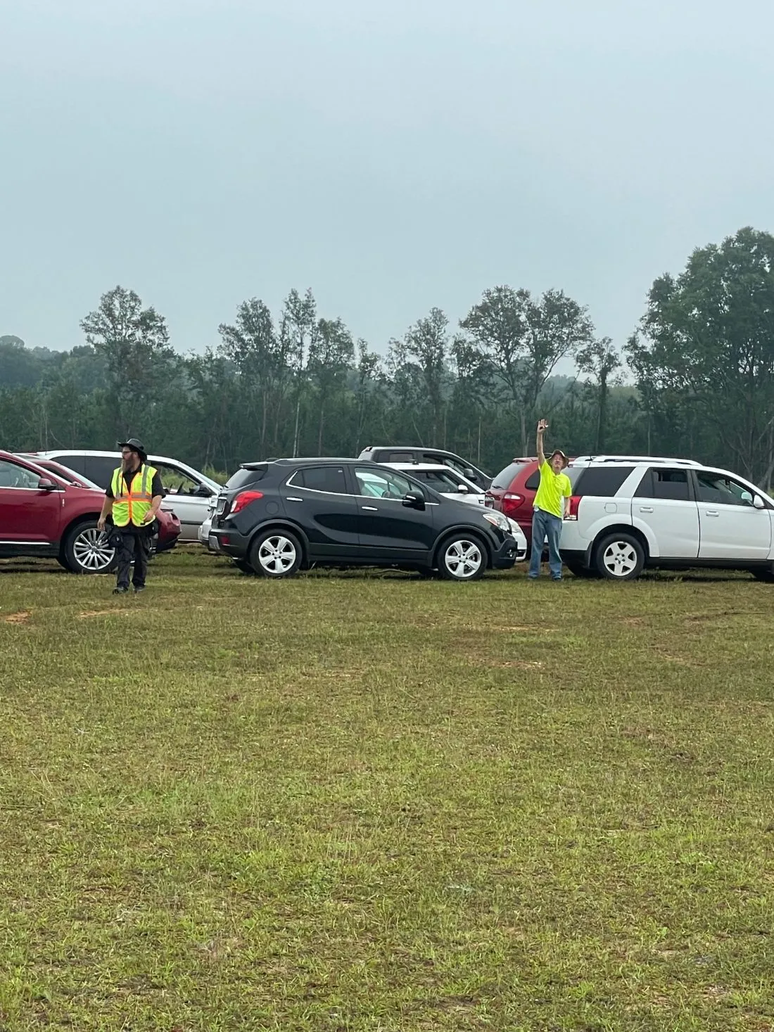 Volunteers in safety vests directing cars at a distribution